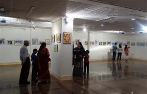 Visitors keenly looking at the paintings by children